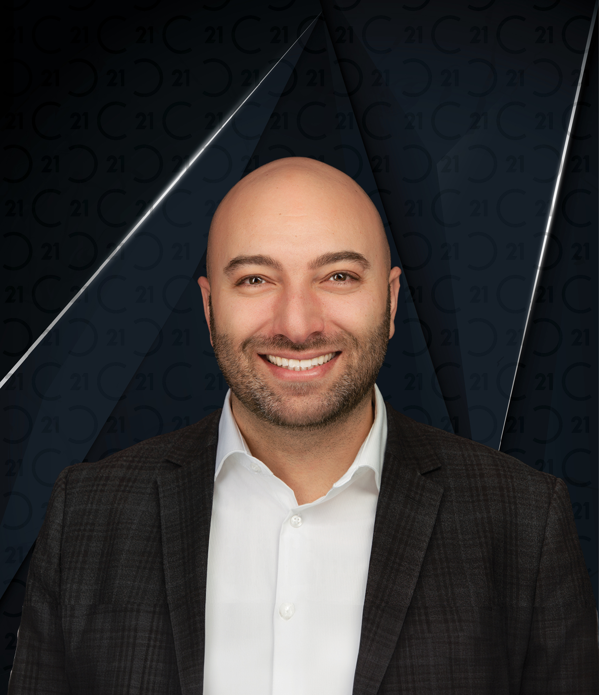 Professional headshot of Dean Soufan, a smiling, bald man with a trimmed beard, wearing a dark plaid suit jacket over a white dress shirt. His name 'Dean Soufan' appears in bold white text to the right. The background features a dark, stylized Century 21 logo pattern with 'CENTURY 21' displayed vertically in the top right corner.
