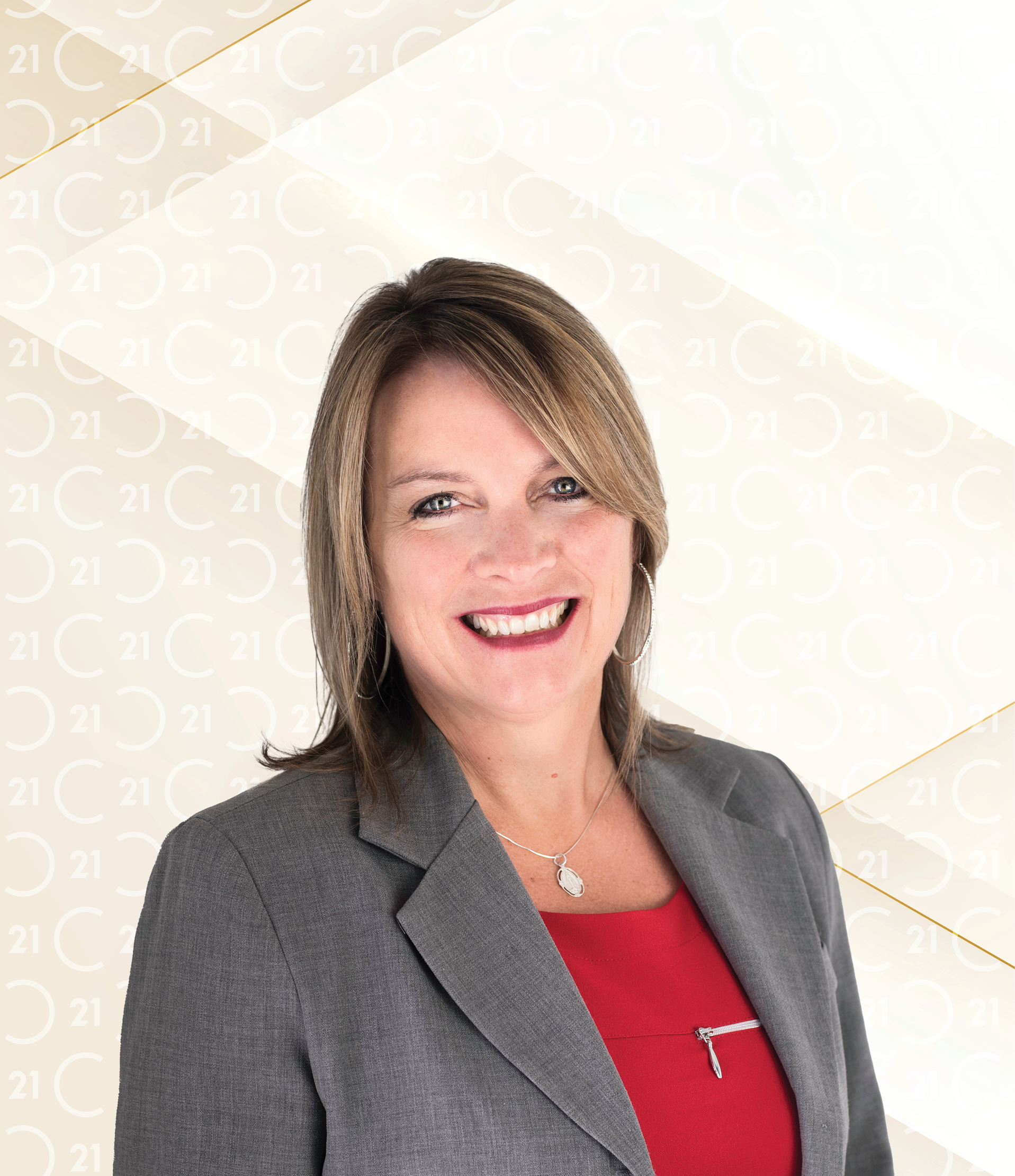 Professional photo of Maureen O’Halloren, a smiling woman with straight, shoulder-length light brown hair, wearing a grey blazer over a red top and a silver necklace. Her name 'Maureen O’Halloren' appears in bold black text to the right. The background is light with a subtle Century 21 logo pattern and gold diagonal accents, featuring the 'CENTURY 21' logo in the top right corner.